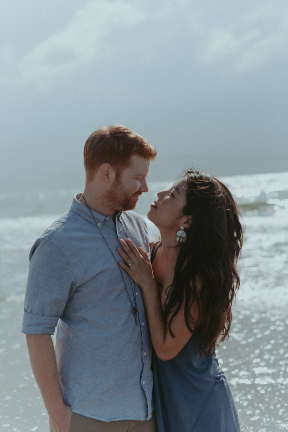 A couple are embracing on the beach.