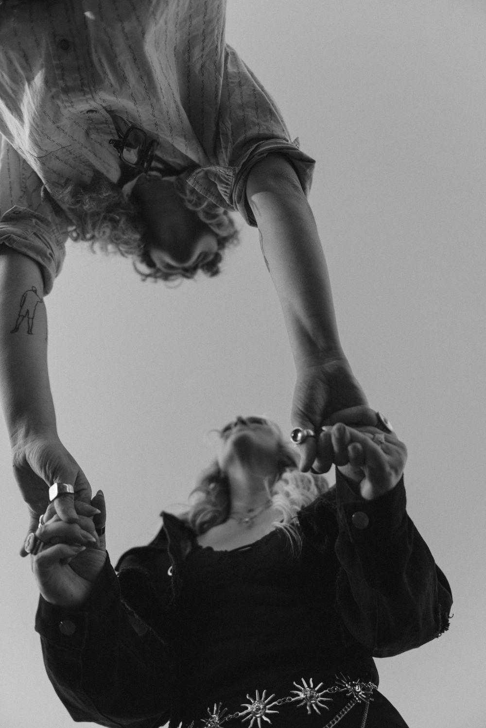 A black and white photo of a couple holding hands.