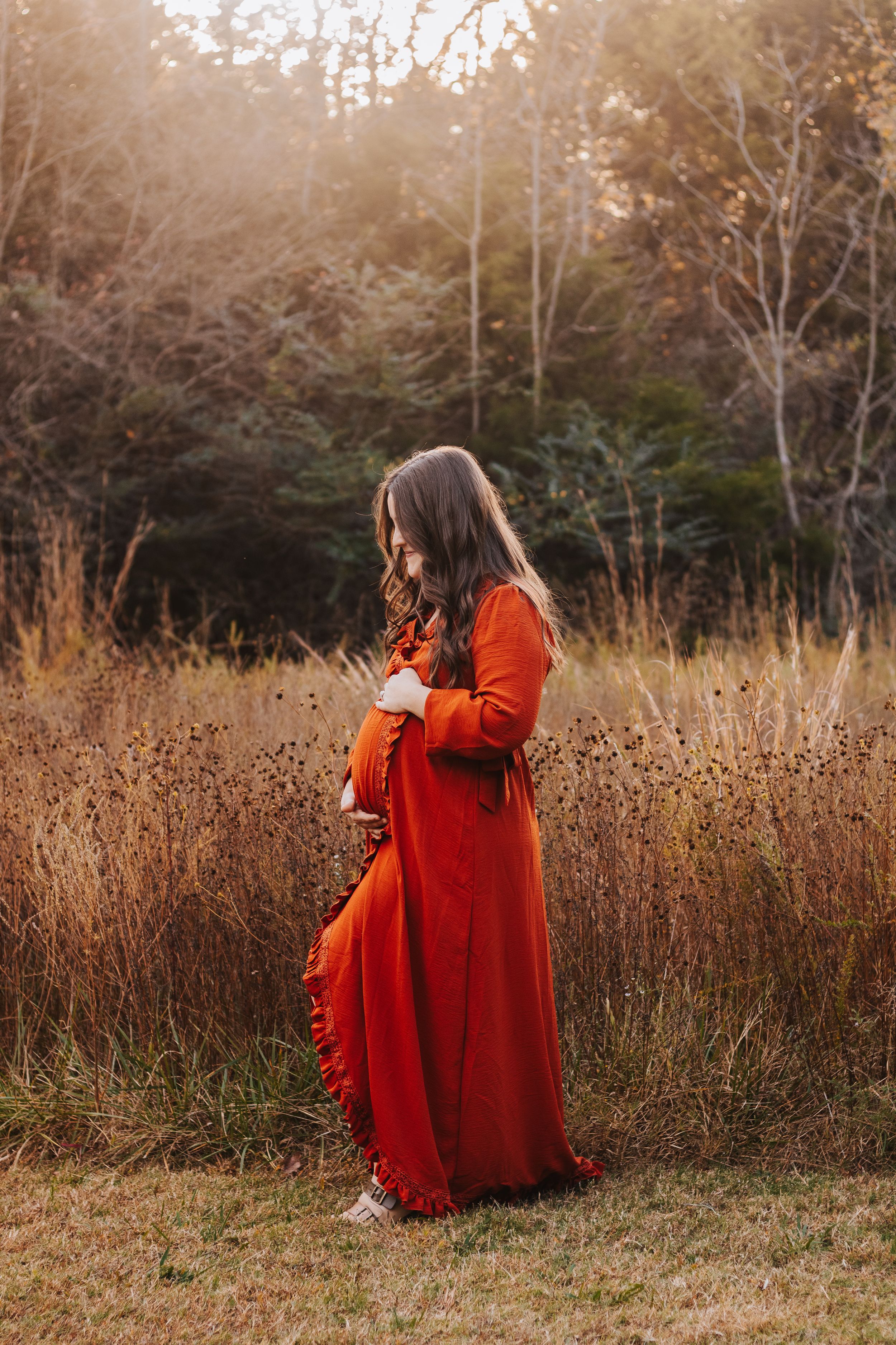 Portrait series of person in flowing red dress posing in autumn field at sunset.