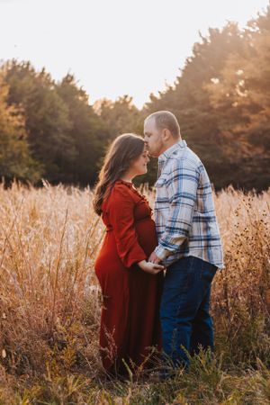 Two people share emotional moments together in golden sunlit field.