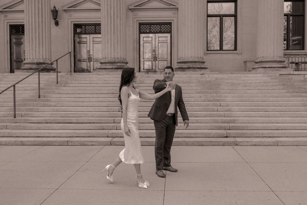Engaged couple dancing outside of Mecklenburg Courthouse in Charlotte, North Carolina