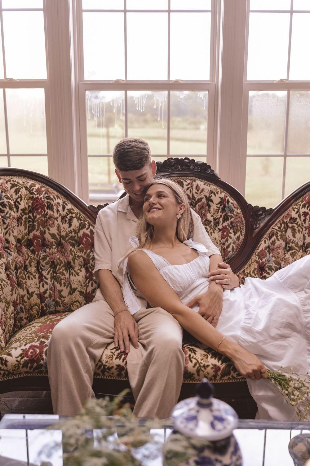 Engaged couple relaxing on a couch at Willow and Stone Events in Mocksville, North Carolina