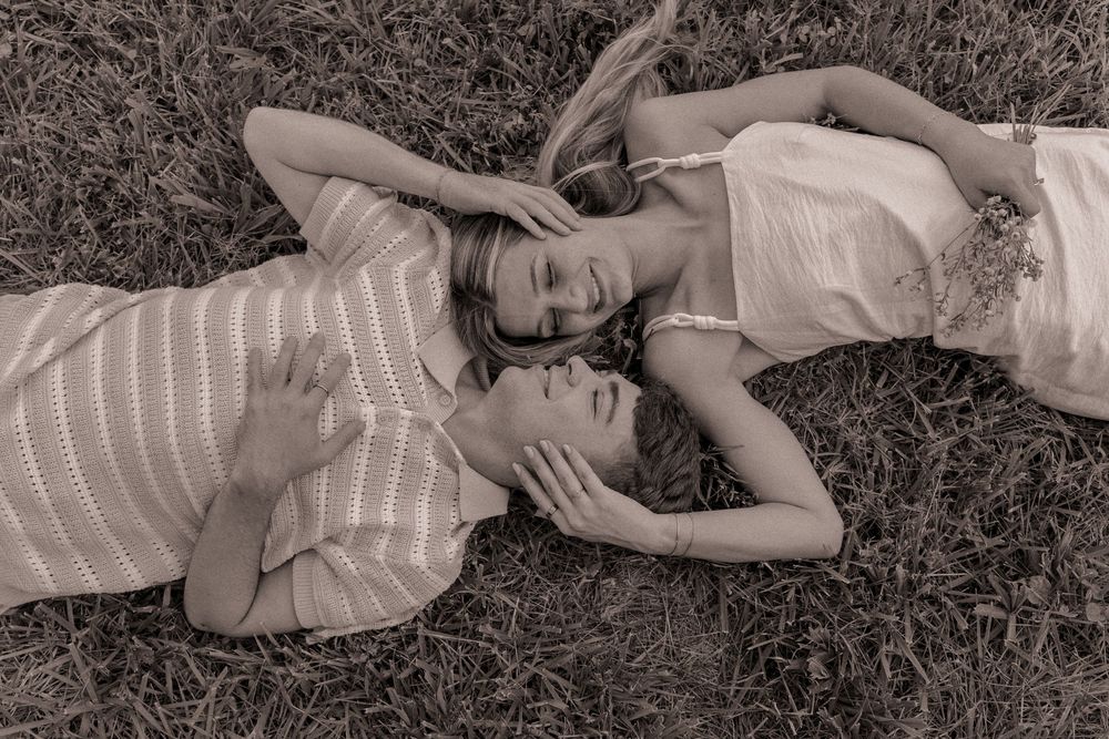 Engaged lying in the grass at Willow and Stone Events in Mocksville, North Carolina