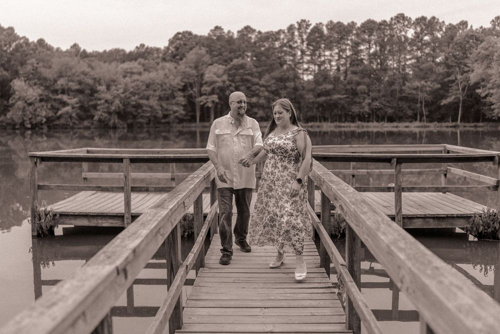 Engaged couple walking together on the dock at Anne Springs Greenway in Charlotte, North Carolina