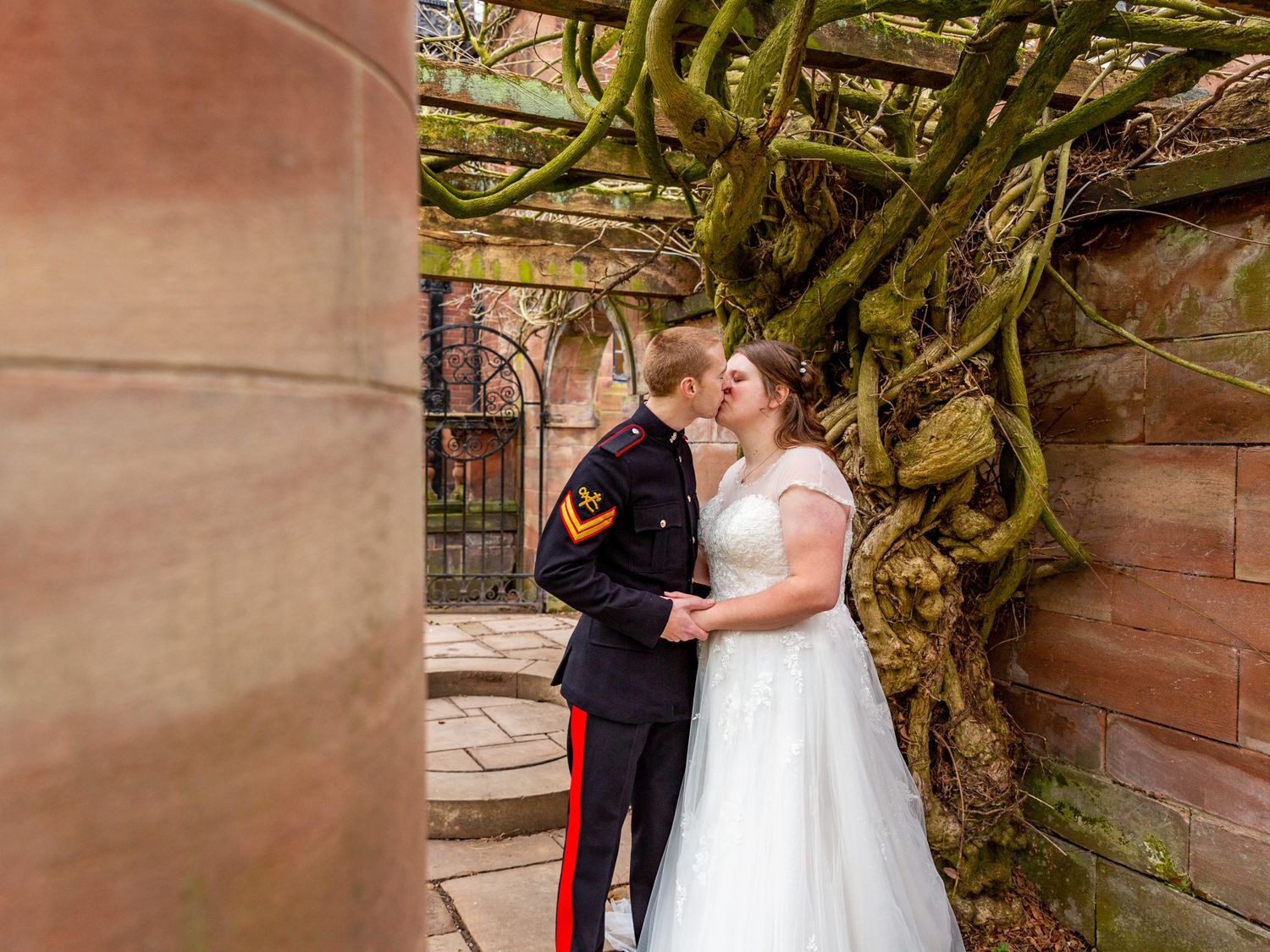 A bride and groom kiss under the pergola at Inglewood Manor. Chester Wedding Photographer. Winter wedding.