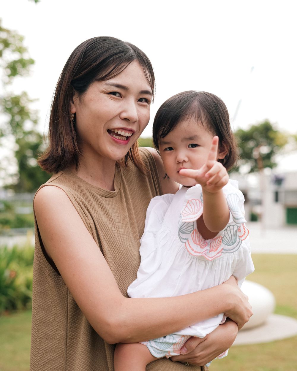 Parent and child pointing at something while enjoying outdoor time together.