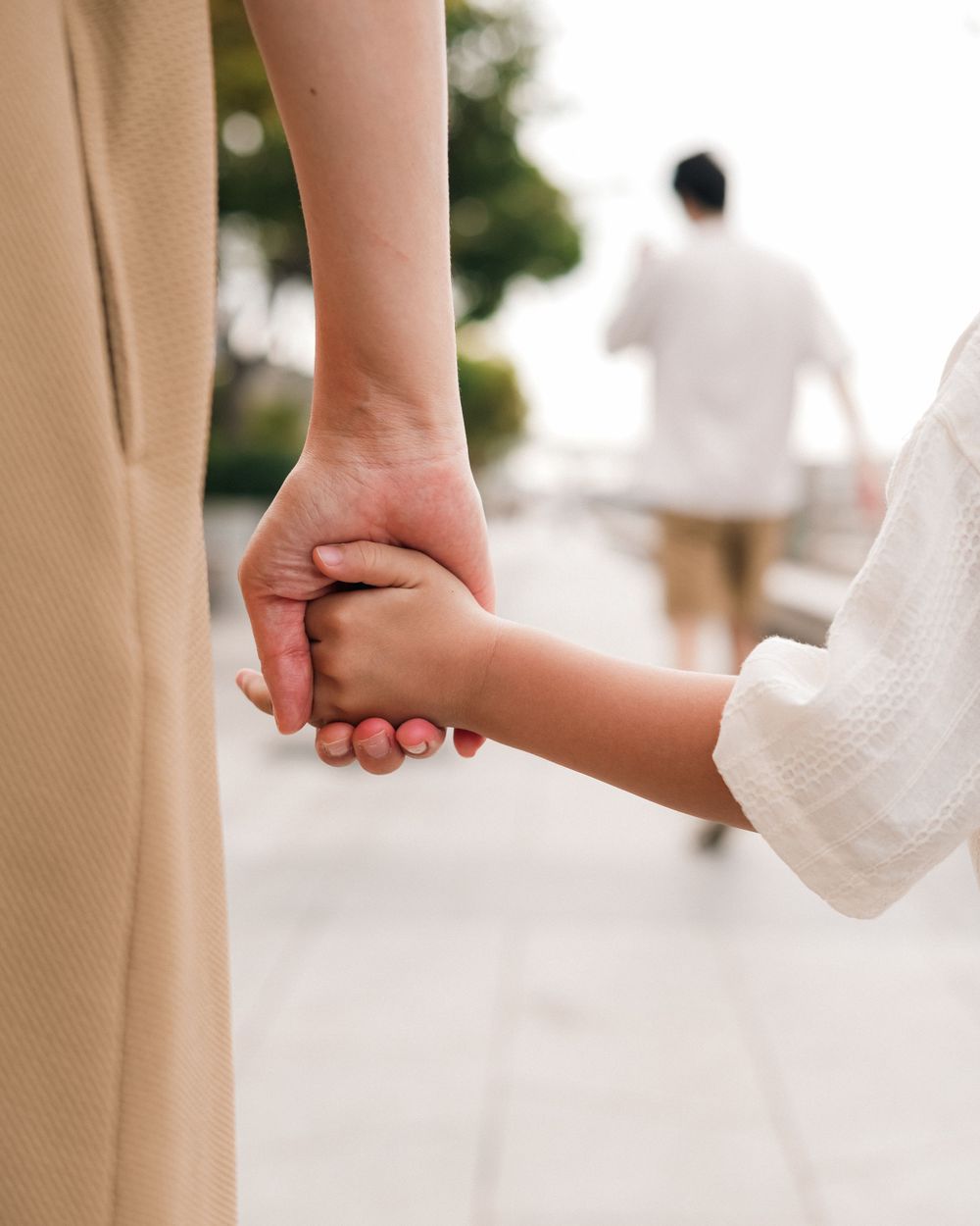 Close-up of hands holding together while walking outdoors.