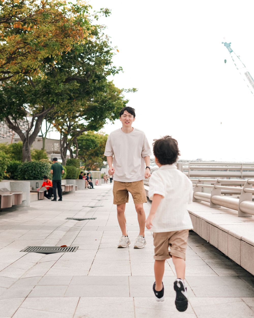 Parent and child walking together on outdoor pathway in Singapore.