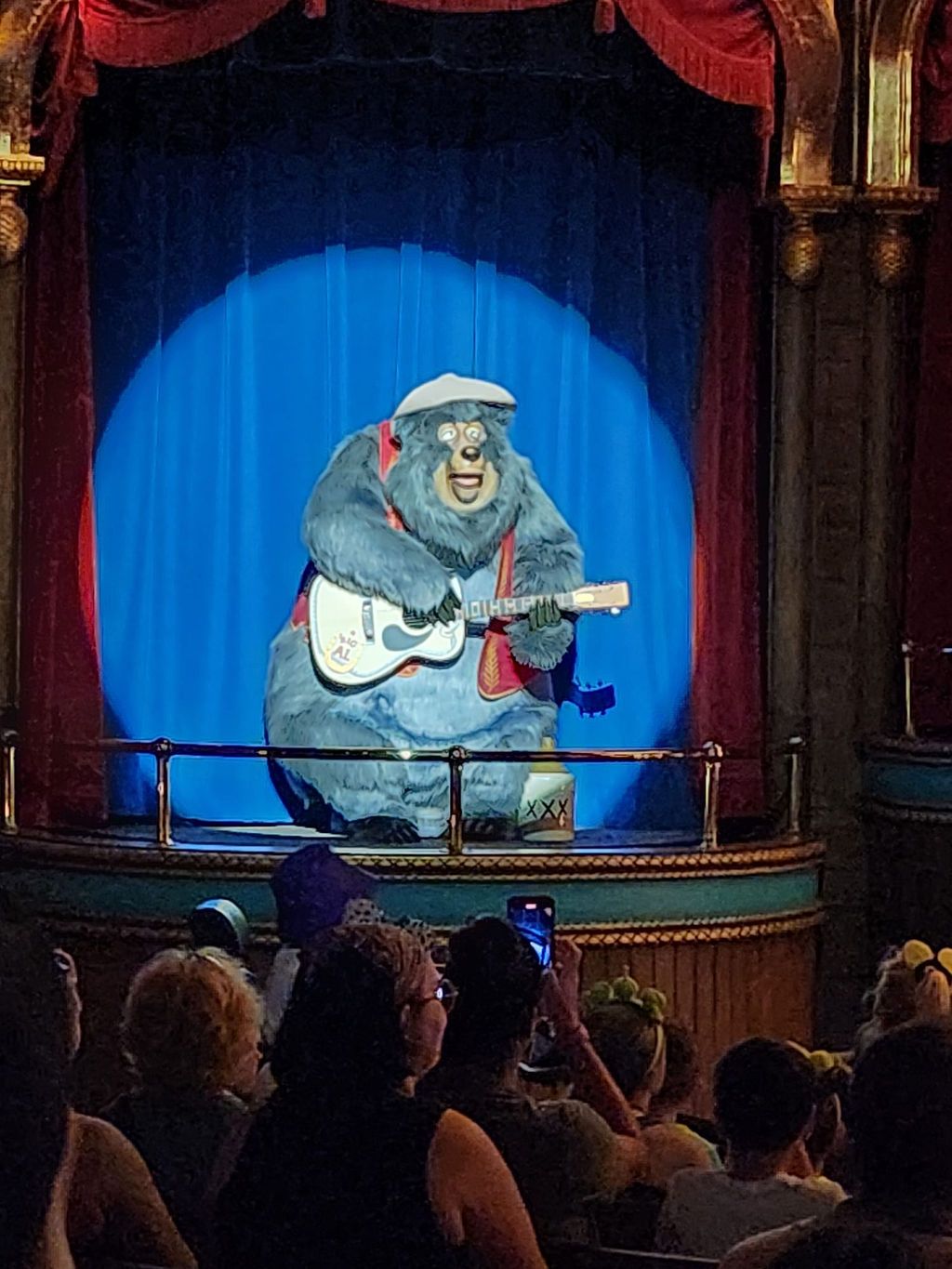 The animatronic Country Bear Jamboree musical attraction features a blue-lit bear playing guitar on stage at Disney World.