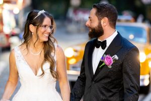 A joyful wedding moment captured on a city street with yellow taxis in the background.