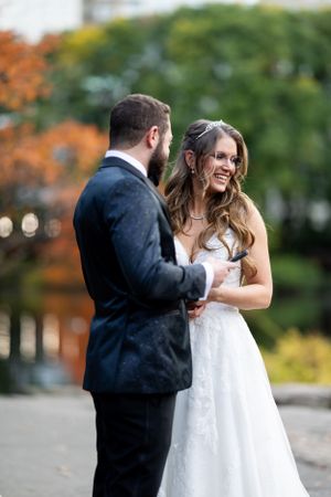 A tender wedding moment captured in an autumn park setting.