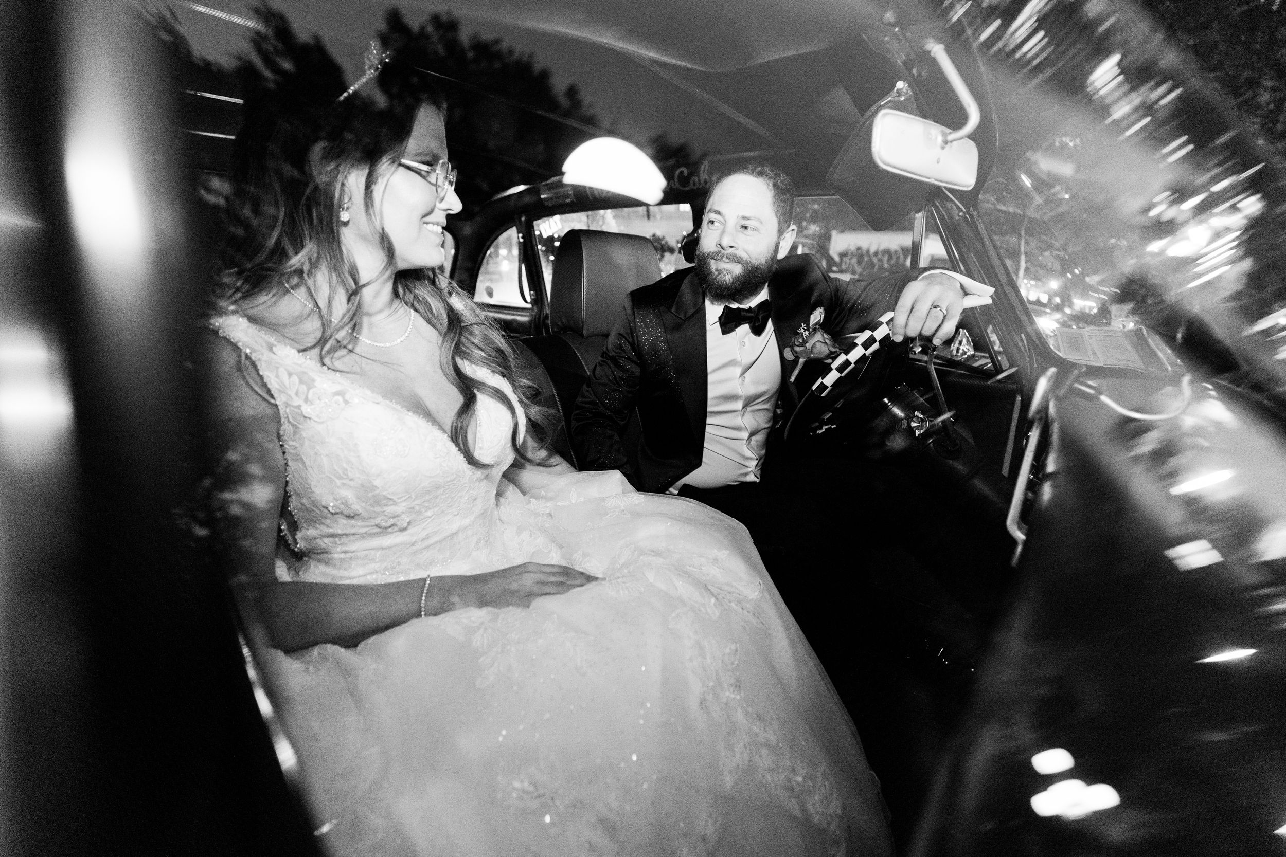An artistic black and white photo inside a moving vehicle at night.