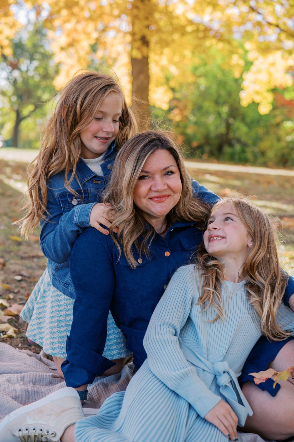 A joyful family moment captured under golden autumn trees.
