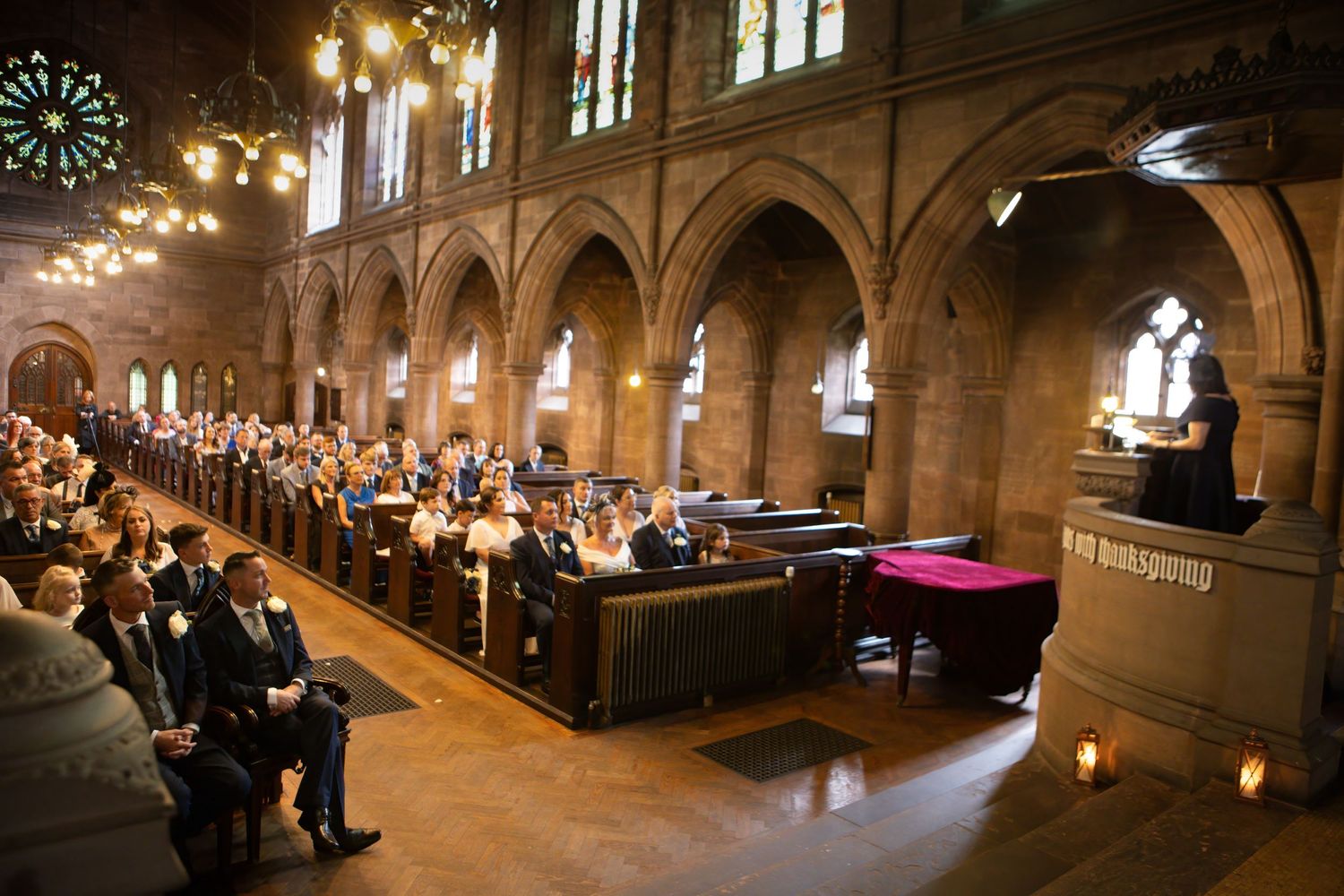 Candlelit church ceremony with warm ambient lighting and stained glass windows.