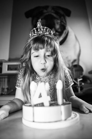 Photo d’une petite fille jouant à souffler des bougies invisibles, jeu d’imitation rempli de douceur en séance photo famille Loire