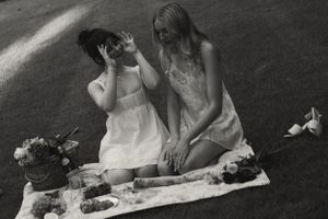 A black and white photo of two people sharing an intimate moment during a romantic picnic.