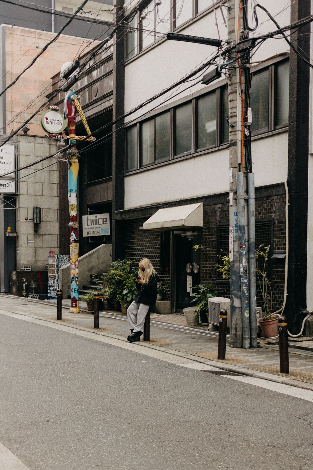 Quiet side street with utility poles and small businesses in Japan.