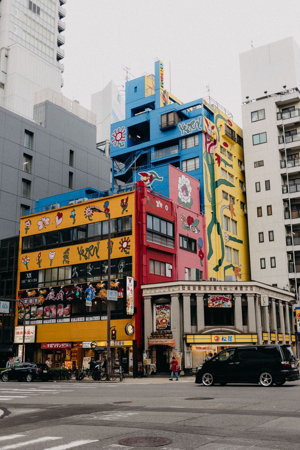 Colorful multi-story building in Japan with anime and manga-style decorations and advertisements.