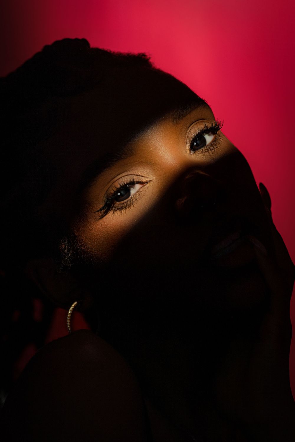 Dramatic portrait series with dark silhouettes against deep red background showing different angles in moody lighting.