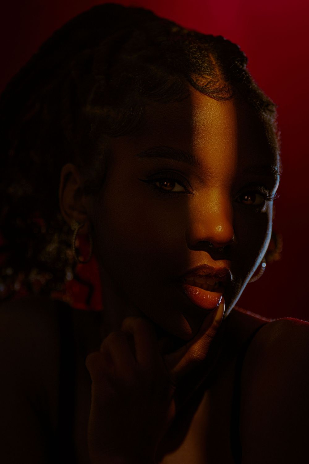 A dramatic series of silhouetted portraits against a dark red background showing different angles and expressions.