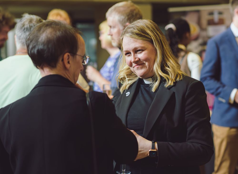 Business people engaged in animated conversation during a networking reception event.