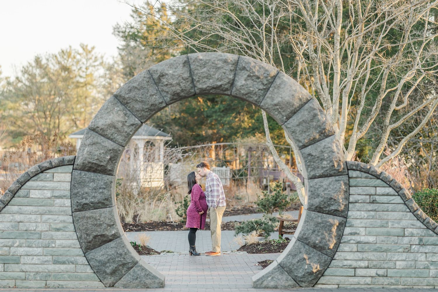 A stone archway in a garden setting creates a romantic backdrop for an intimate outdoor moment.
