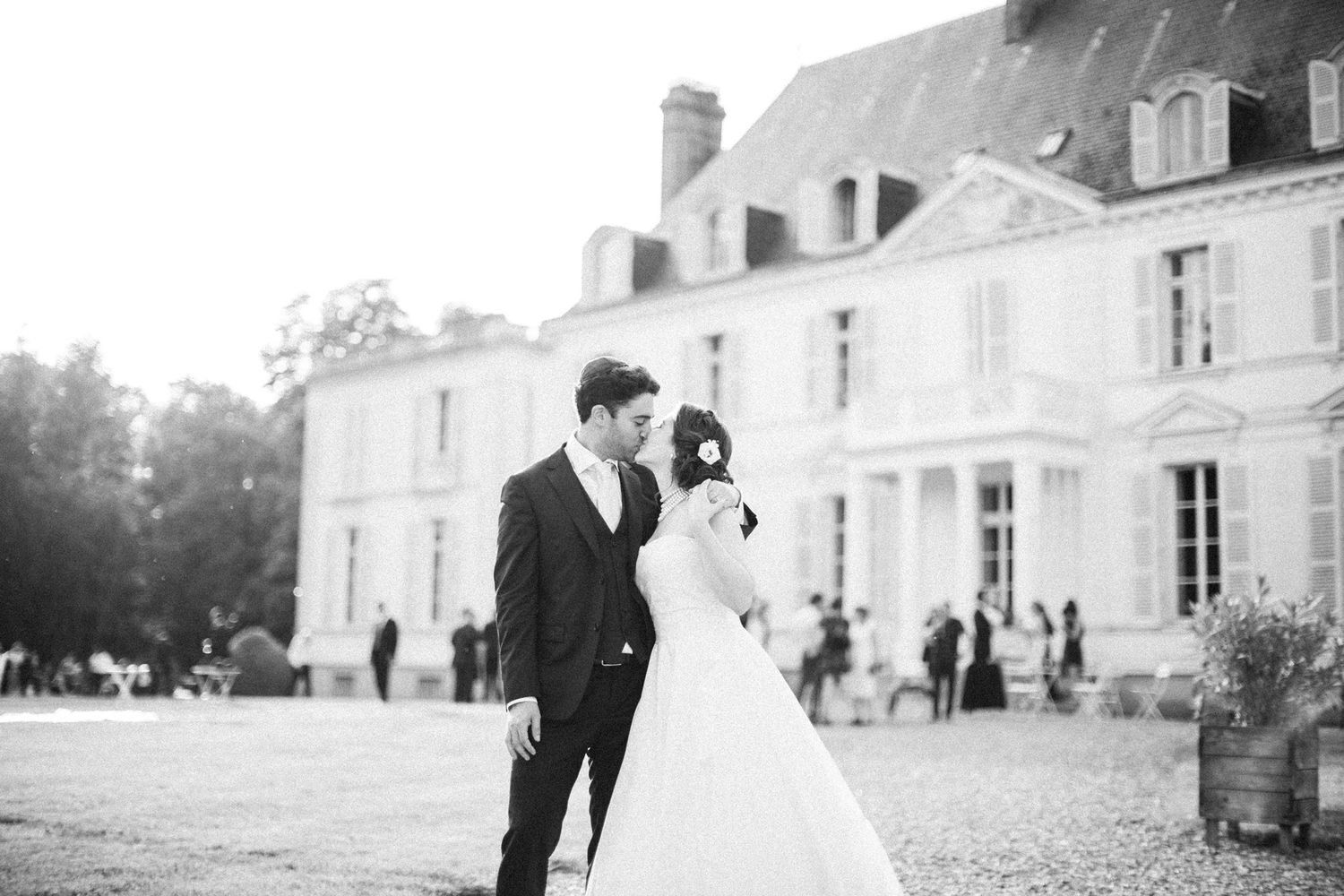 Bride and groom embracing in front of Château Barthélemy during a wedding near Paris