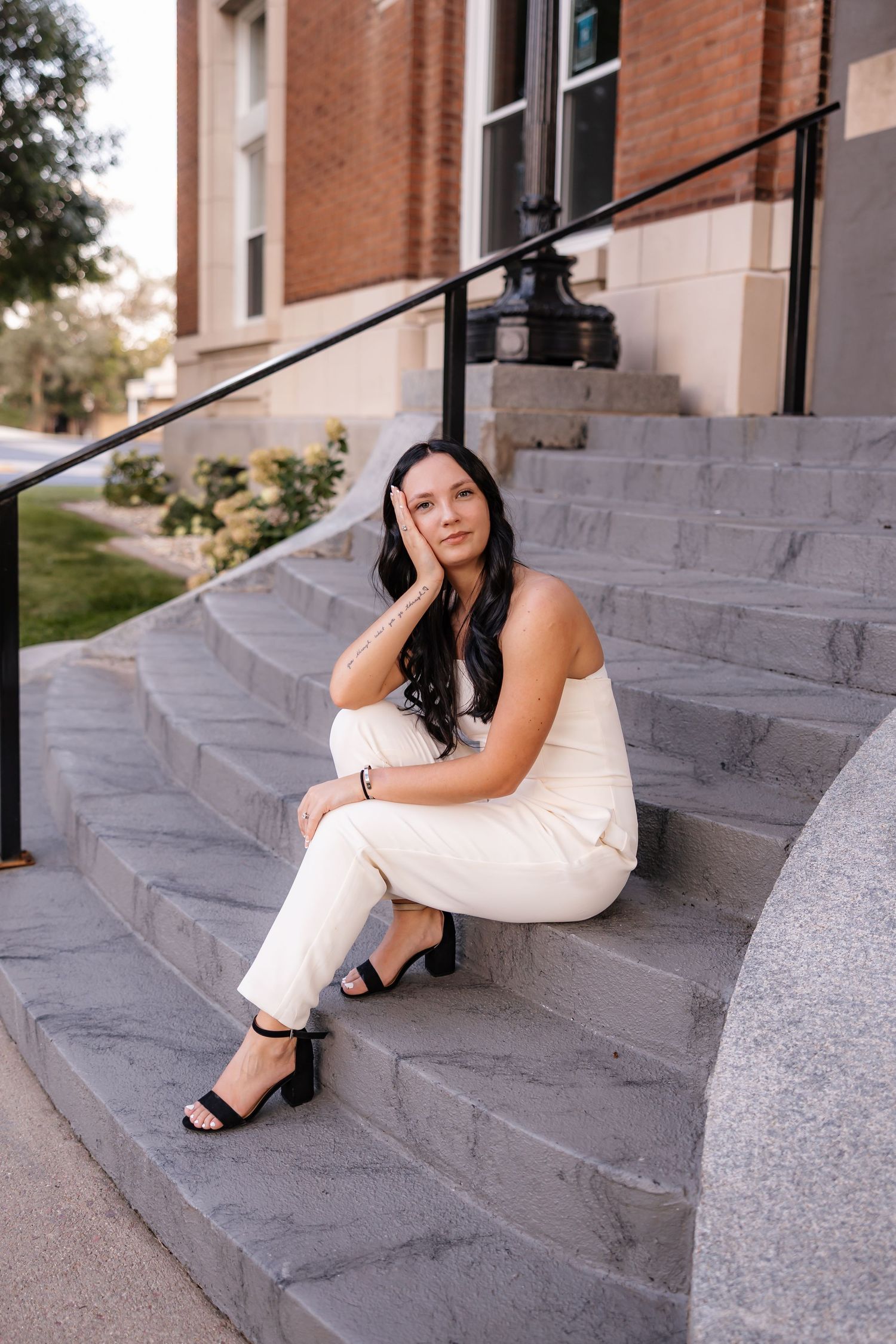 Person in white collared top sitting outdoors during golden hour lighting.