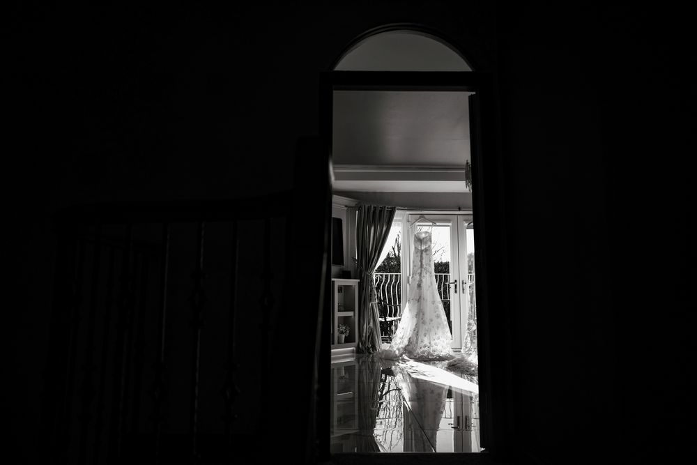A flowing wedding veil billows dramatically in black and white against a dark background.