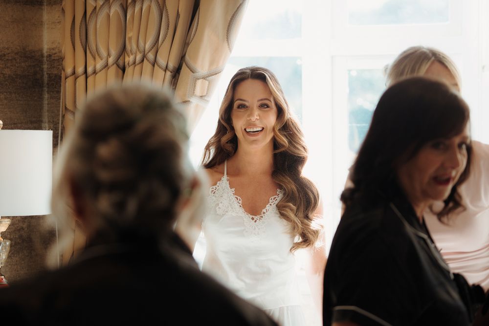A soft focus artistic wedding scene showing silhouettes and blurred figures in natural light.