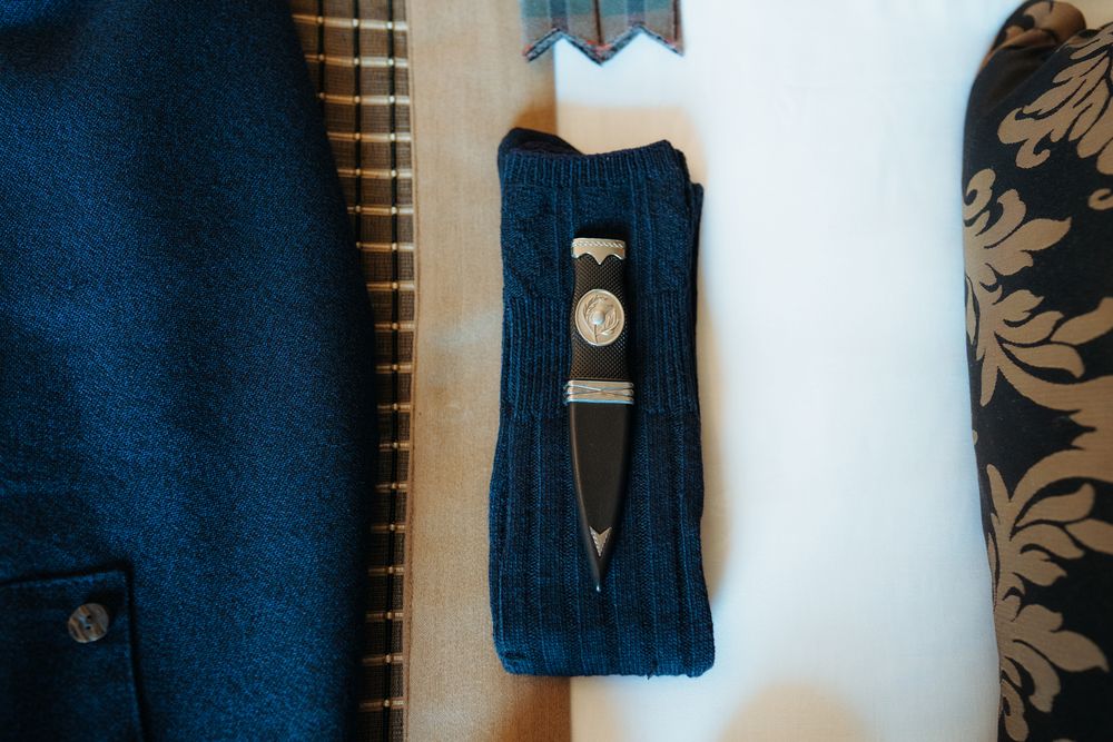 Navy blue knitted sweater with cable pattern details displayed on a white background.