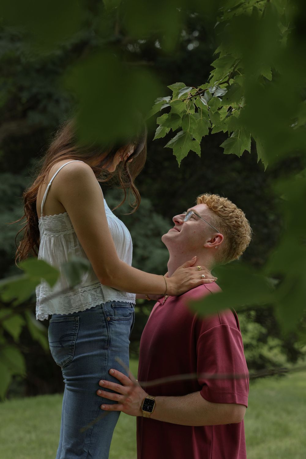Woman standing on bench looking down at man as they face each other