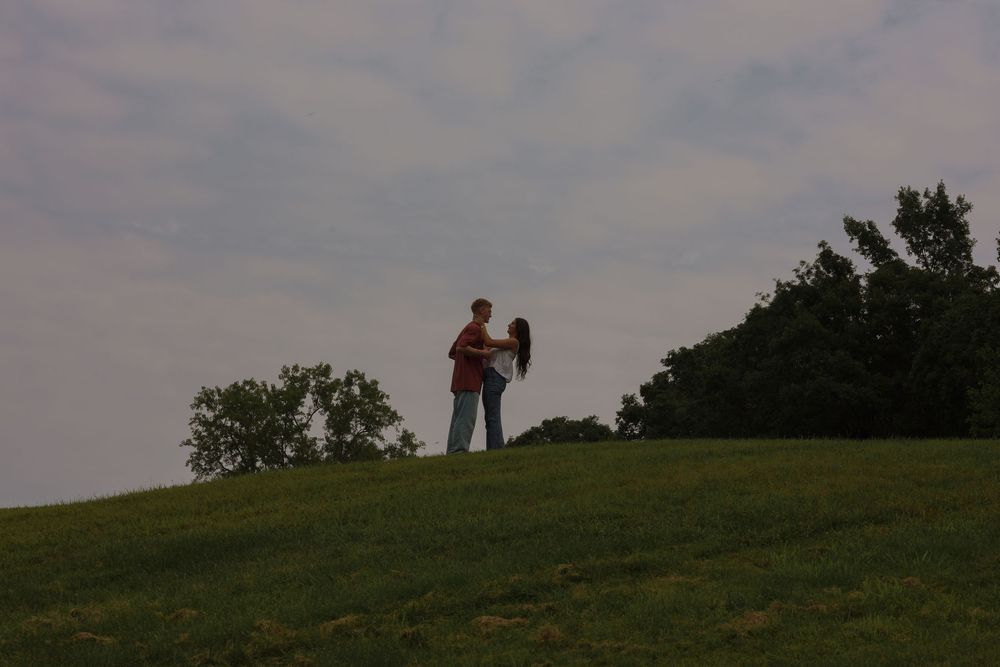 Man and woman embracing on top of hill