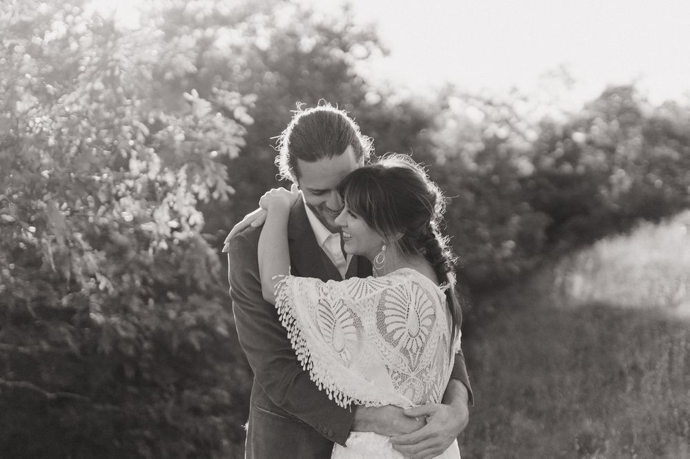 A romantic black and white photo series of a couple embracing in an outdoor garden setting.