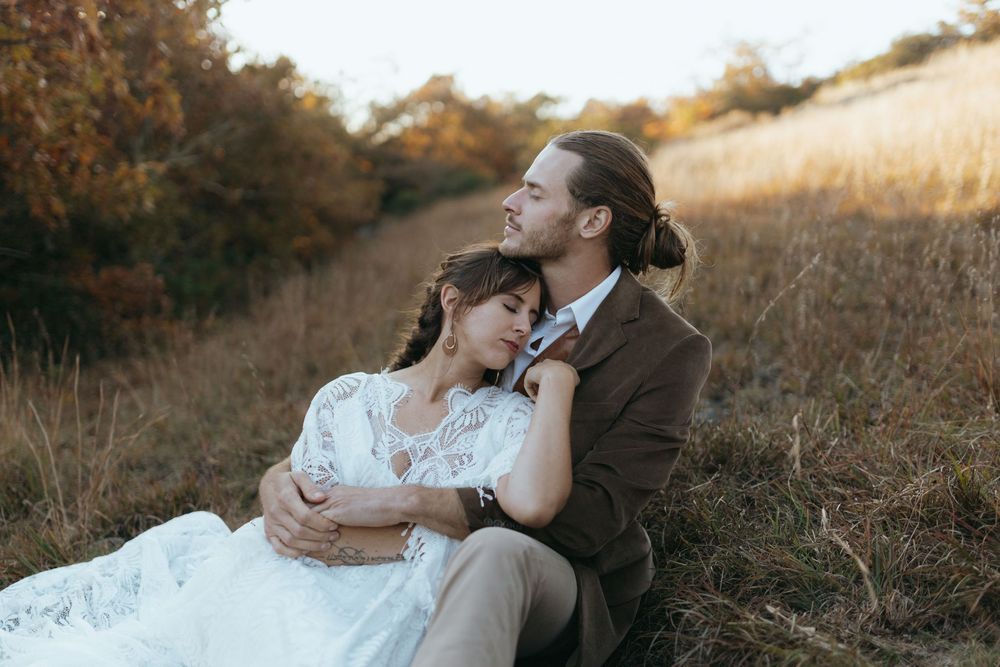 A romantic couple embraces in a golden field during sunset in a series of intimate wedding photos.