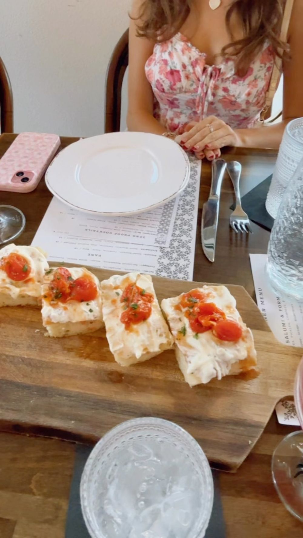 Appetizer bites topped with smoked salmon served on a rustic wooden board at an elegant table setting.