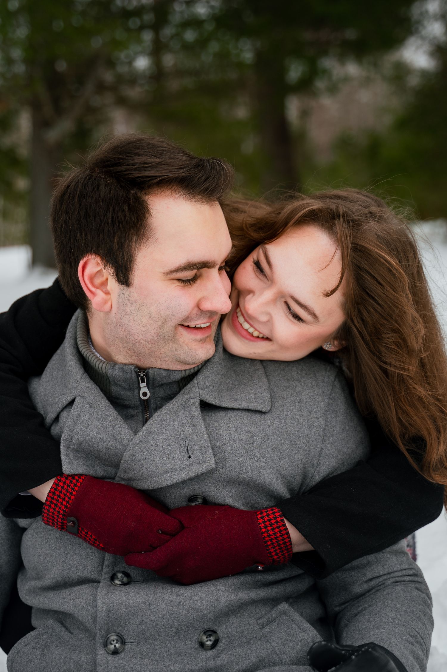 A couple in gray winter coats embraces and shares tender moments in a romantic outdoor photoshoot sequence.