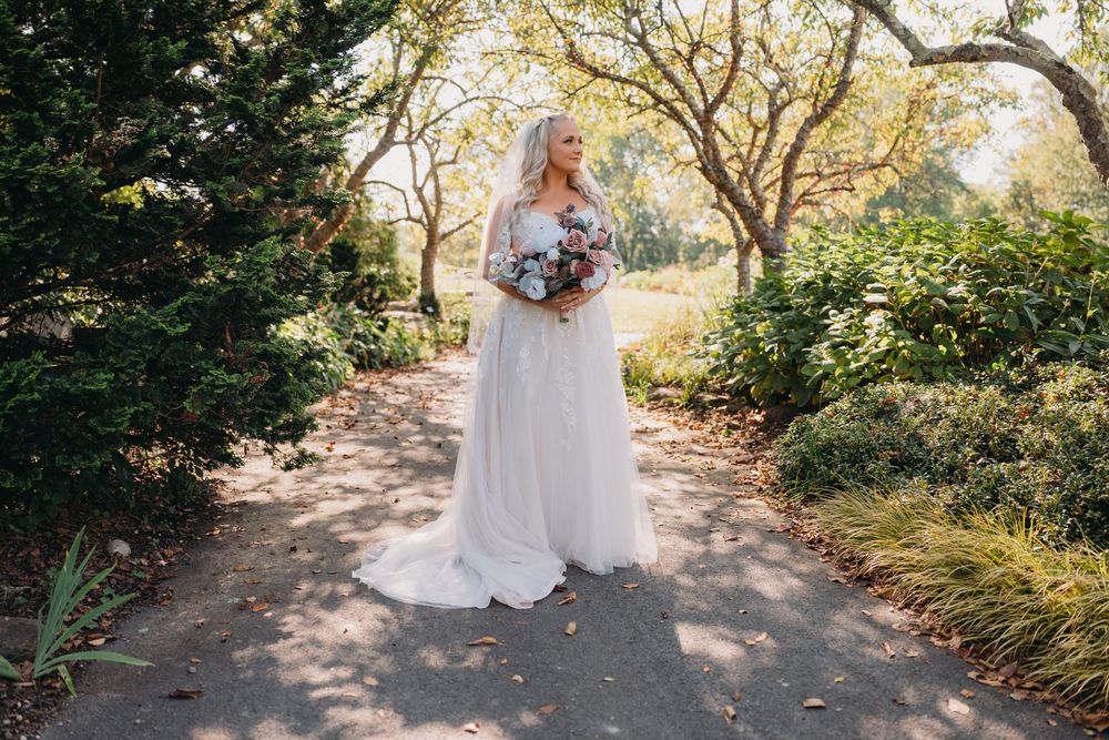 A romantic garden wedding with white floral arrangements and sunlit pathways at the Atrium at Meadowlark Botanical Garden