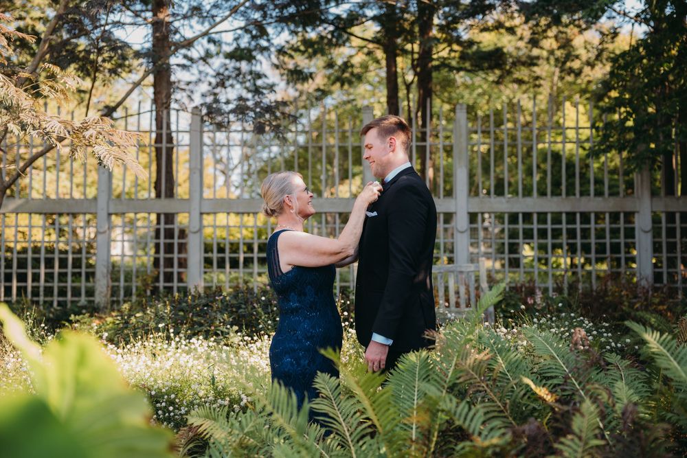 Elegant wedding ceremony taking place in a lush garden setting with white floral decorations at the Atrium at Meadowlark