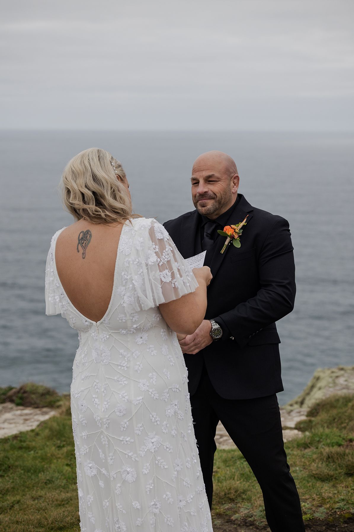 Bride and groom reading vows at Hags Head overlooking the Atlantic Ocean