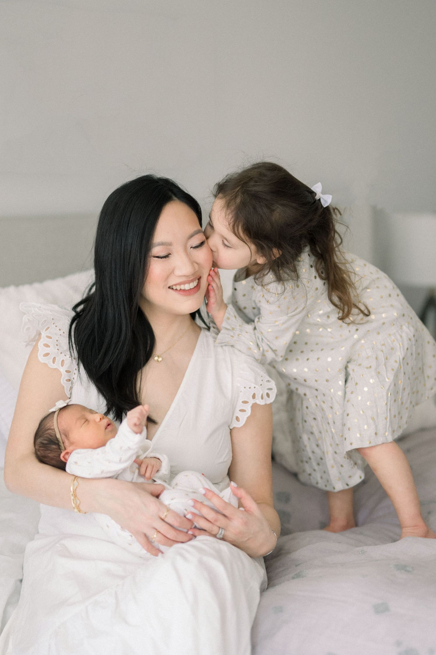 mom and children on bed at a washington dc newborn session