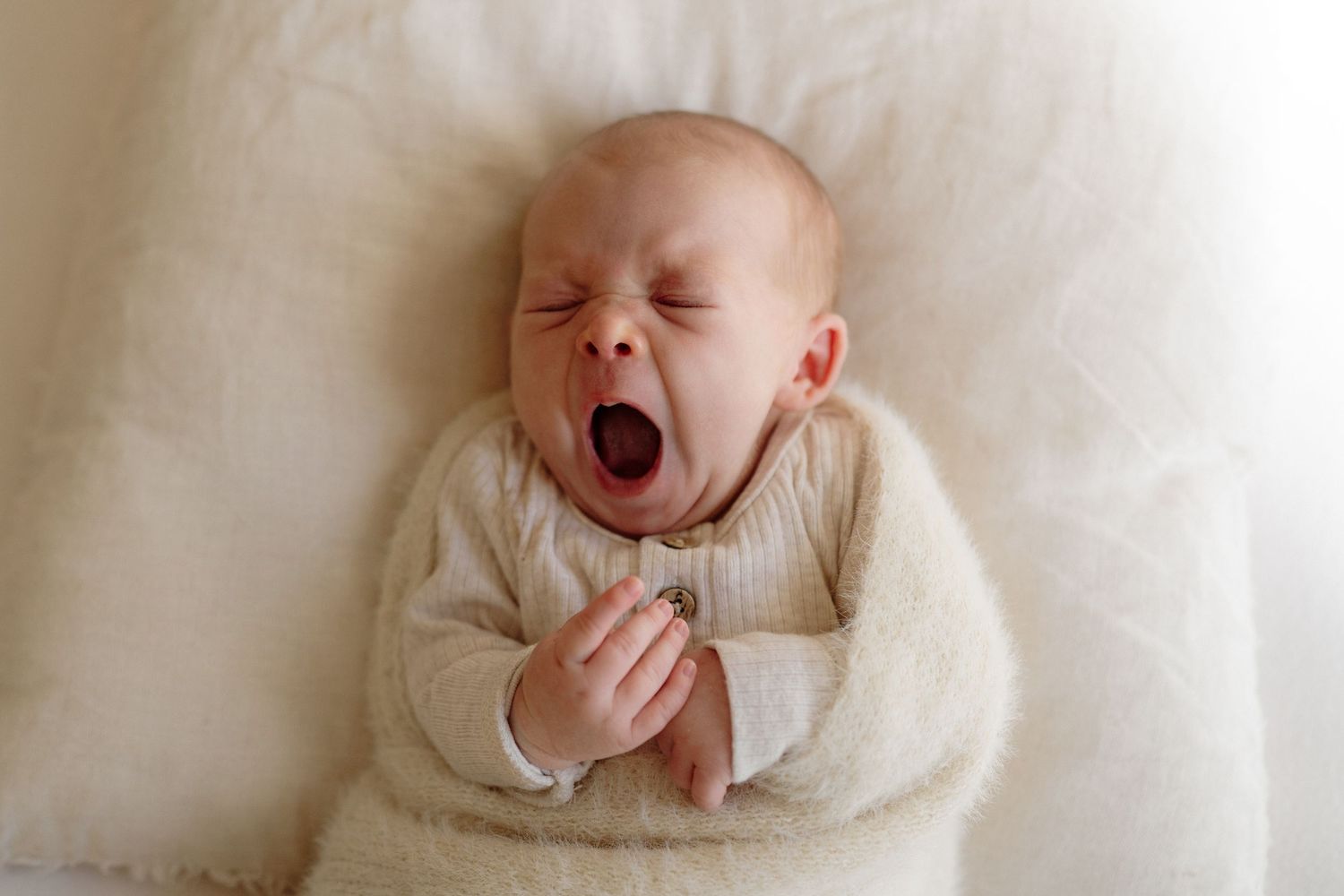 Close up of newborn baby wrapped in soft blanket during in-home session