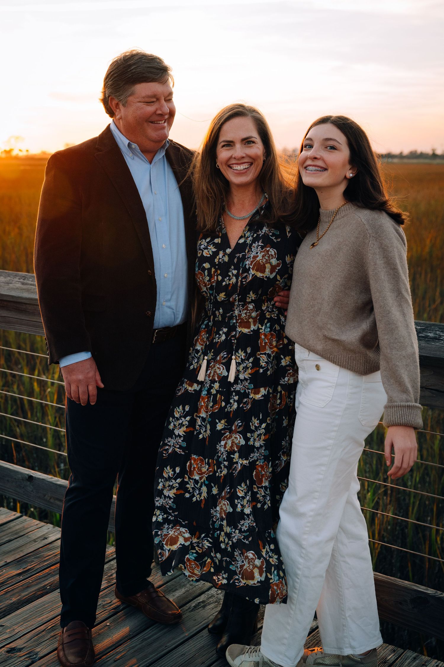 Family sitting together on outdoor steps during golden hour sunset at a park.