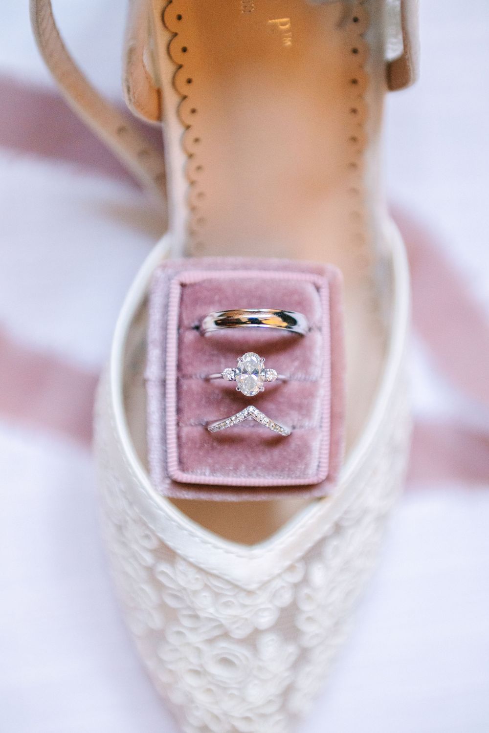 Wedding rings displayed in pink velvet ring boxes showcasing elegant diamond engagement and wedding band sets.