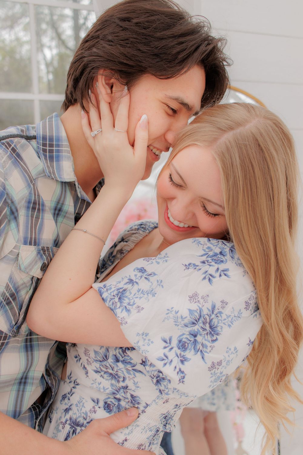Couple in plaid and floral clothing sharing tender moments against white background.