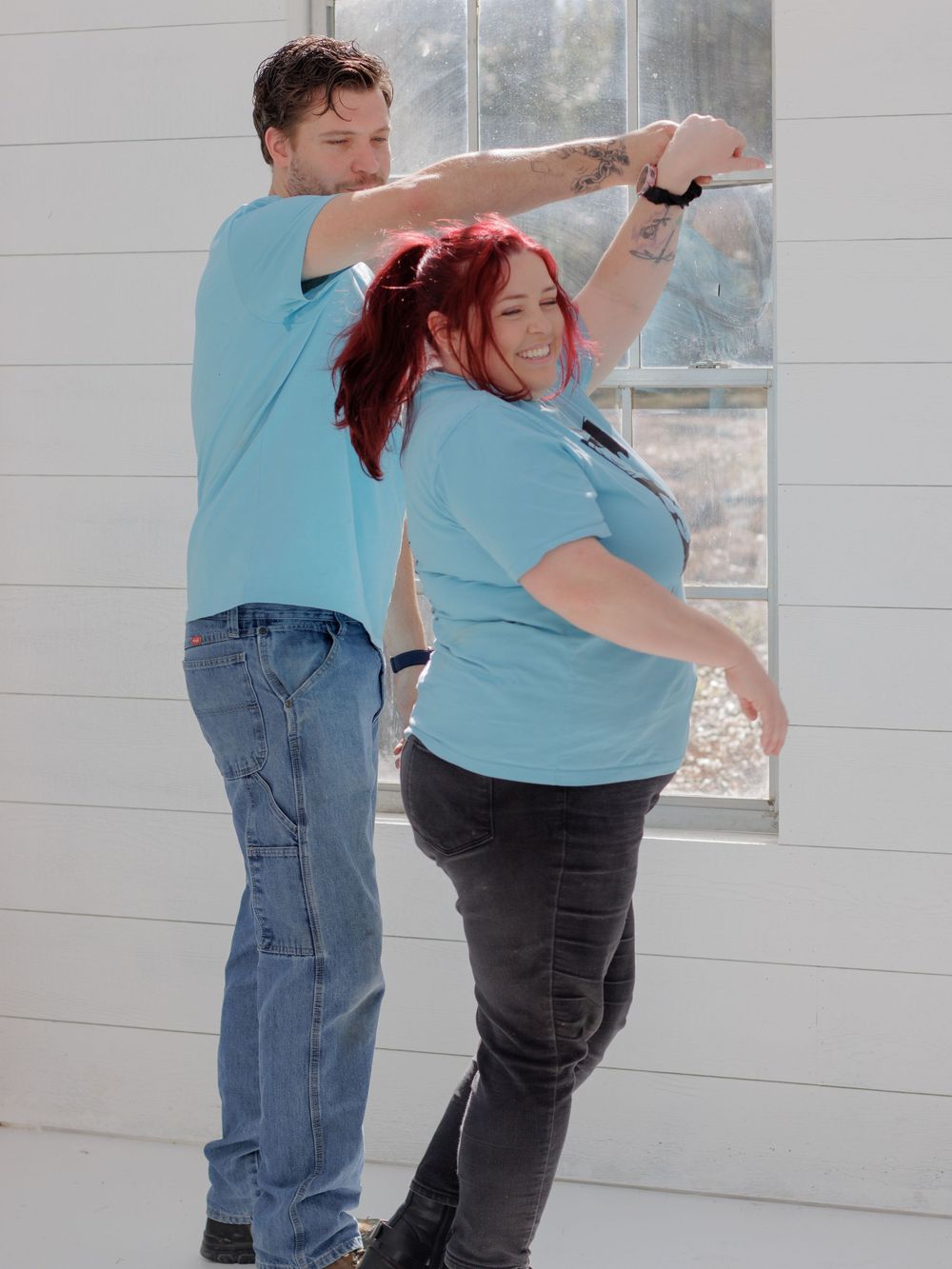A young couple embracing and smiling in a casual setting.