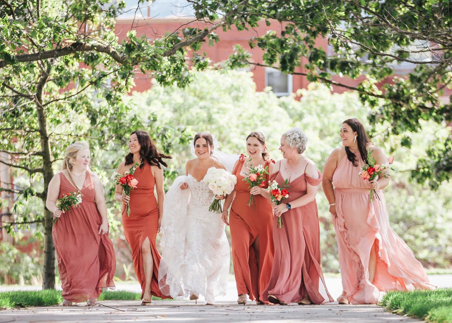 Bride walking with bridesmaids during wedding portraits at Dorchester Heights in South Boston