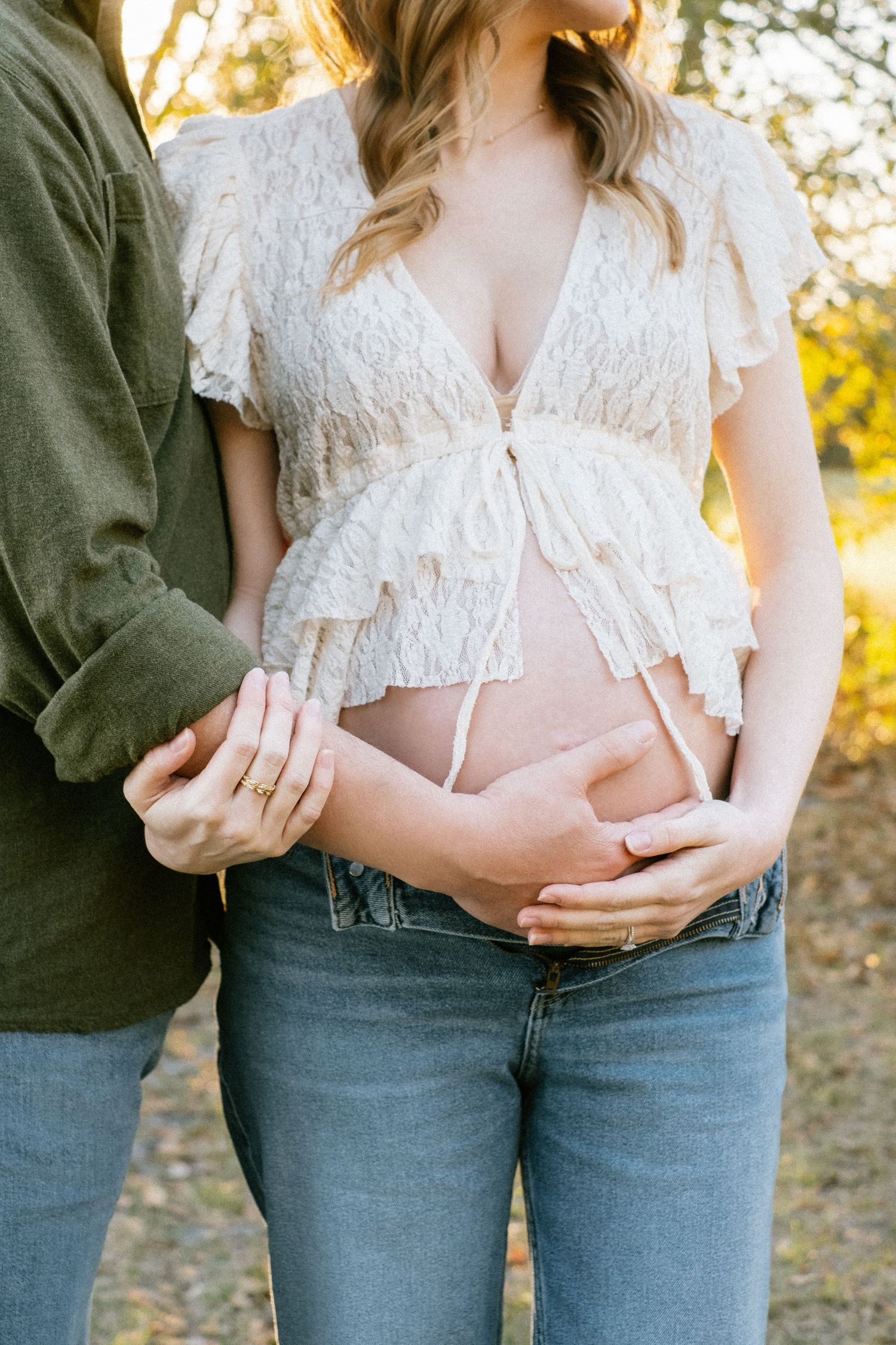 Close up maternity photo showing hands on baby bump during outdoor Jacksonville maternity session