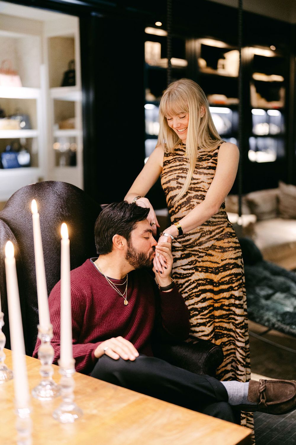 A romantic candlelit scene with a couple sharing an intimate moment on a couch.