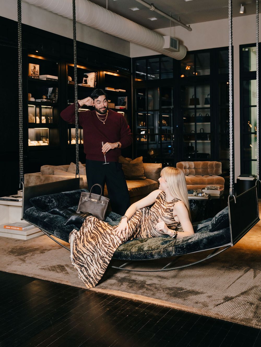 A couple lounges together on a gray sectional sofa in a modern industrial-style room.